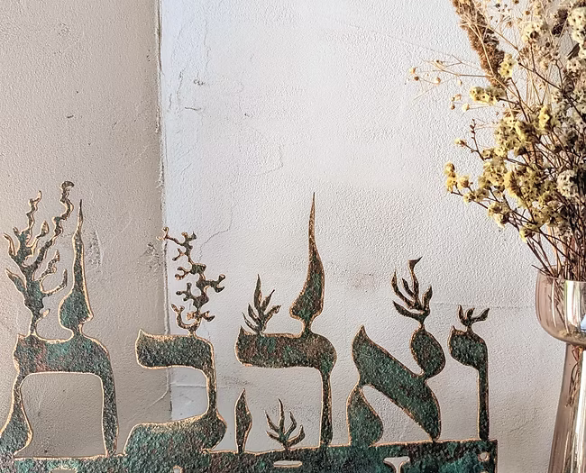 פמוט לנרות שבת “ואהבת”. נחושת יצוקה ידנית על ברזל, זוג קני זכוכית פיירקס ופתיליו